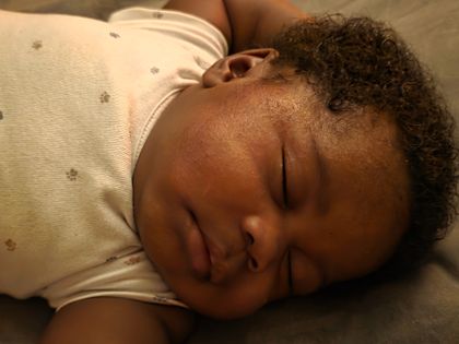 A beautiful picture of my baby sleeping nicely wearing her pampers.