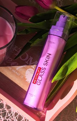 Une jolie mise en scène autour du Revitalift Glass Skin de L’Oréal Paris 💜
Le flacon violet est posé sur un plateau en bois, entouré de tulipes roses et d’une bougie, avec une lumière douce qui crée une ambiance chaleureuse et élégante. 