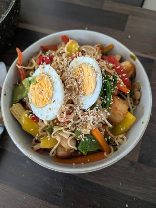 Soba noodles, stir fry chicken and vegatables topped with a boiled egg crispy chilli oil and toasted sesame seeds . 